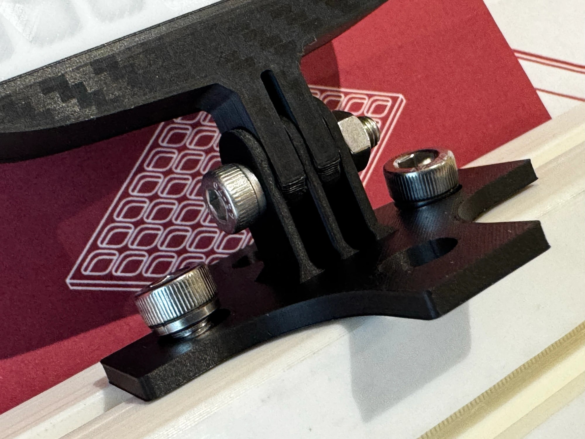 Close-up of the iFlag: GT Edition adjustable stand - a GoPro-style tilt joint on a forked foot with thumbscrews, clamped onto aluminium extrusion, fitting both 4040 and 8040 profiles
