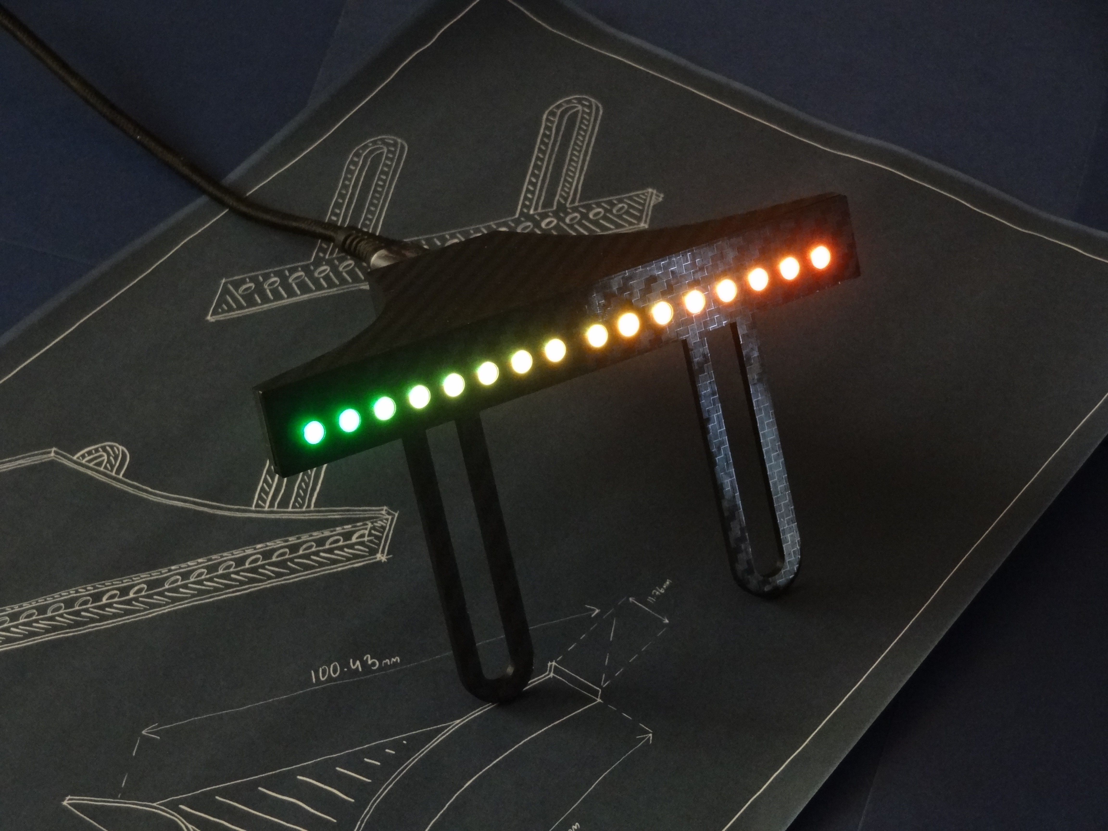 Rev Gauge F1-style shift lights sweeping green to red, carbon-fibre bar standing on a sim racing design blueprint