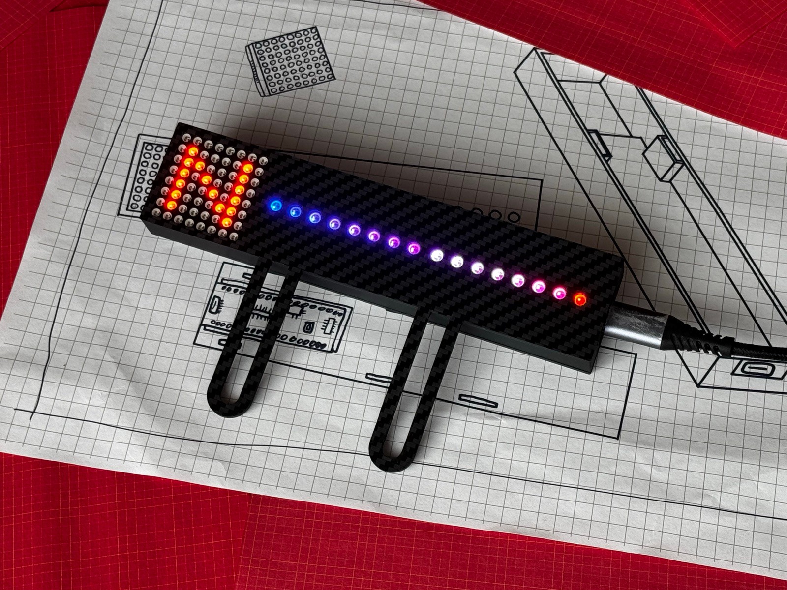 Gear Indicator + Shift Lights on its carbon-fibre Fanatec mounting legs, gear matrix lit red with a custom blue-to-red rev sweep - fully customisable 24-bit ARGB LEDs, USB-C connected