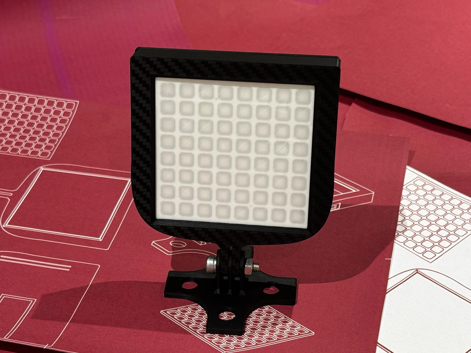 iFlag: GT Edition with the LEDs off, showing the carbon-fibre-effect housing and 8x8 LED diffuser grid on its tilt bracket, on oesimracing design blueprints