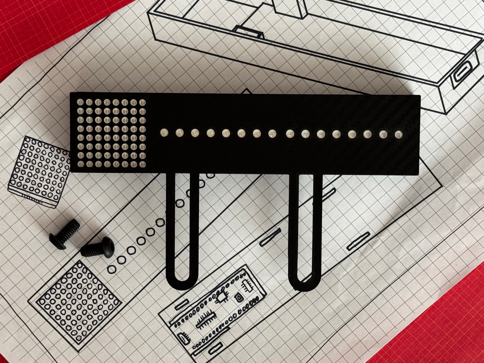 Unlit Gear Indicator + Shift Lights on its two carbon-fibre Fanatec mounting legs, shown with the two included M6 mounting bolts, on oesimracing design blueprints