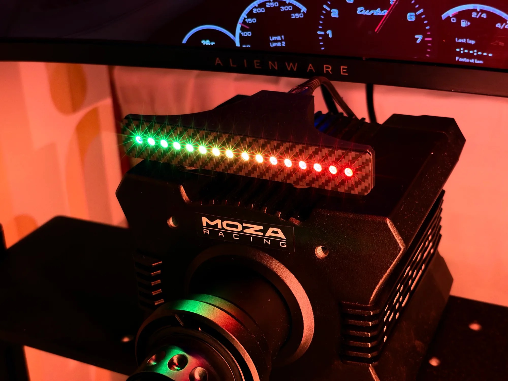 Shift Lights Pro on a MOZA wheelbase, lit green through amber to red across all 16 LEDs, with the rev counter on the monitor behind it