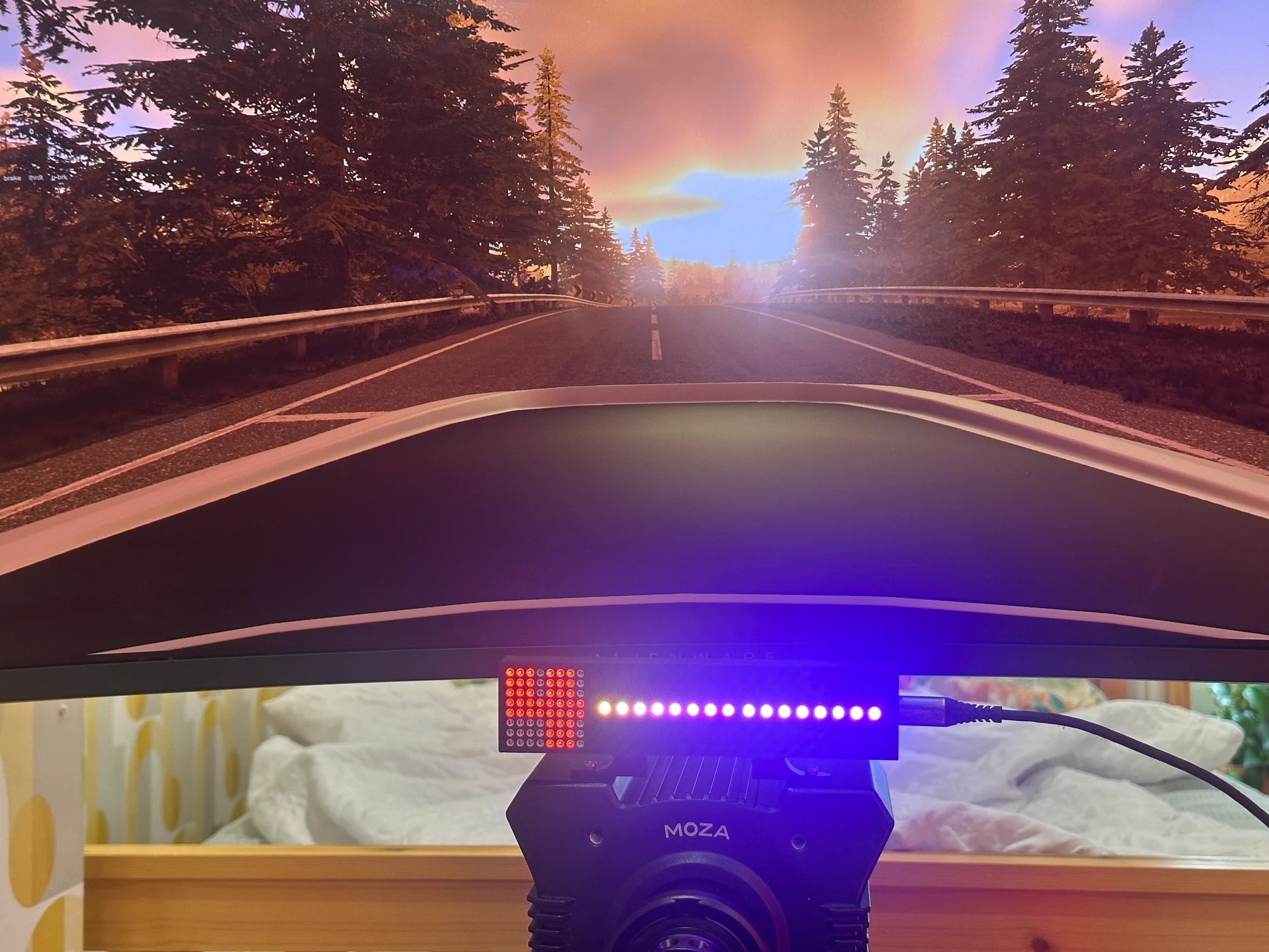 The Gear Indicator + Shift Lights on a MOZA wheelbase in front of the game running on screen