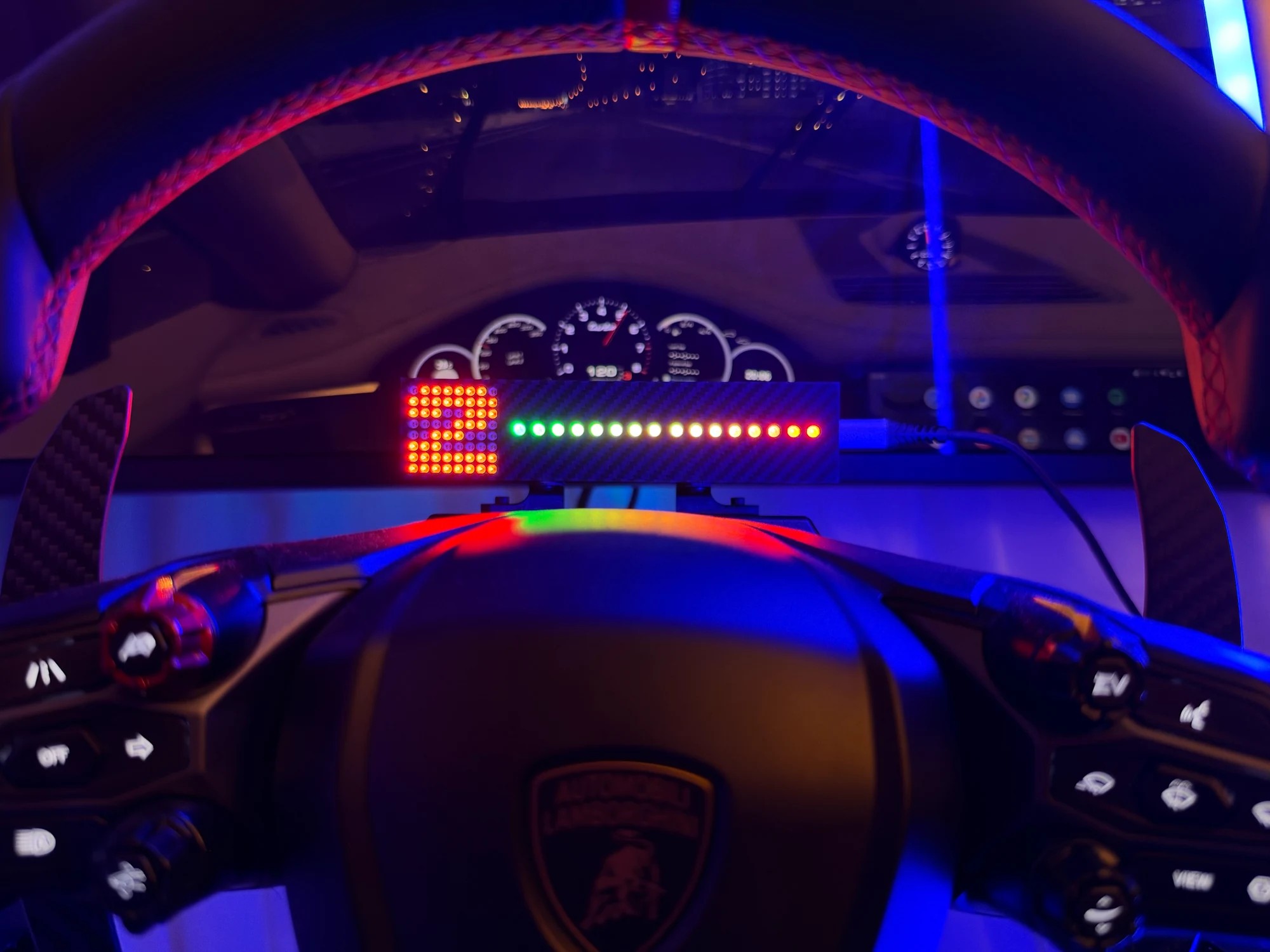 The gear number and shift bar seen through the top of the steering wheel mid-corner, readable without looking away from the road
